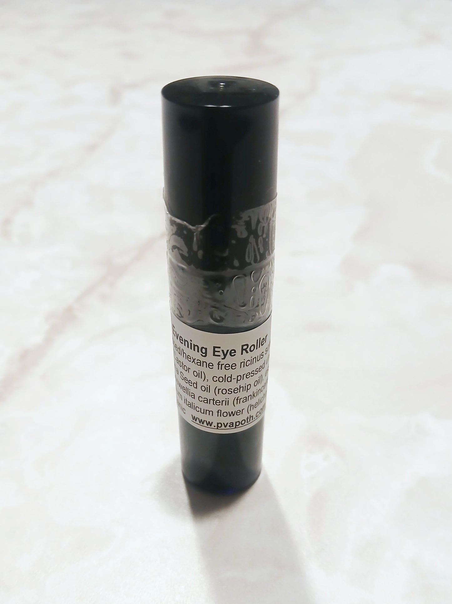 picture of an amber 10ml roller bottle labeled with ingredients for the evening eye roller