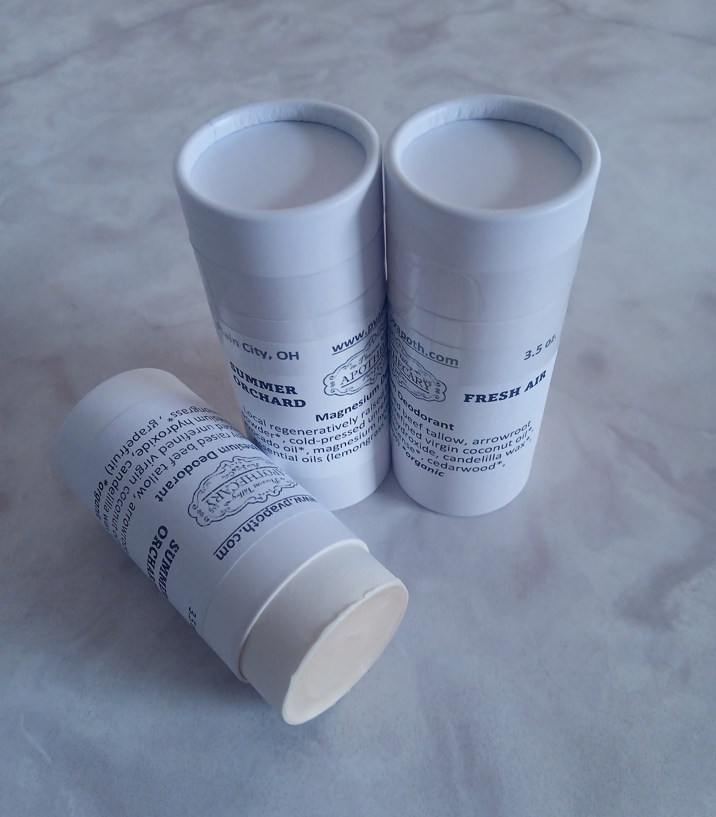 3 stick deodorants, 2 standing and one on its side that is open