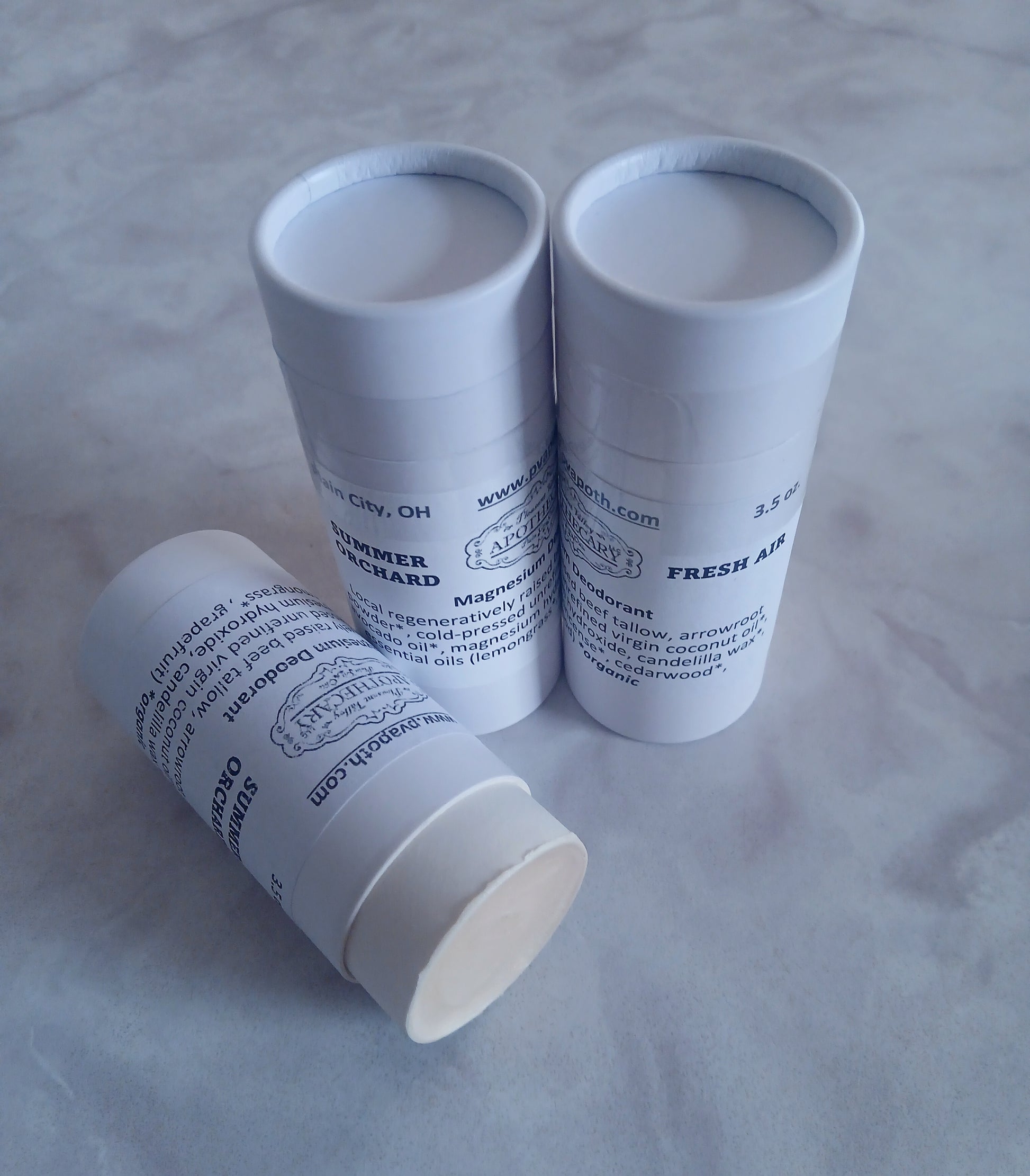 3 stick deodorants, 2 standing and one on its side that is open